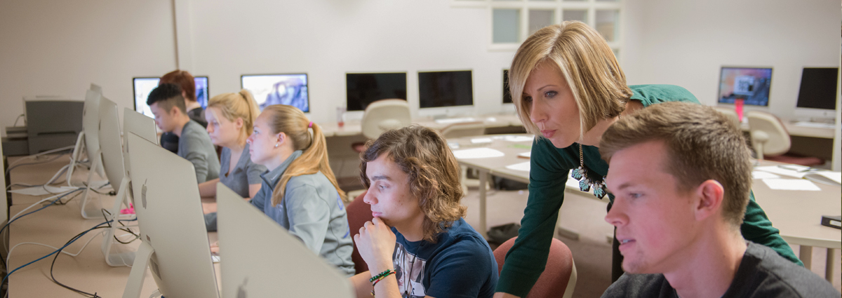 Cabrini students and Professor Jeanne Komp in a graphic design class at computer stations
