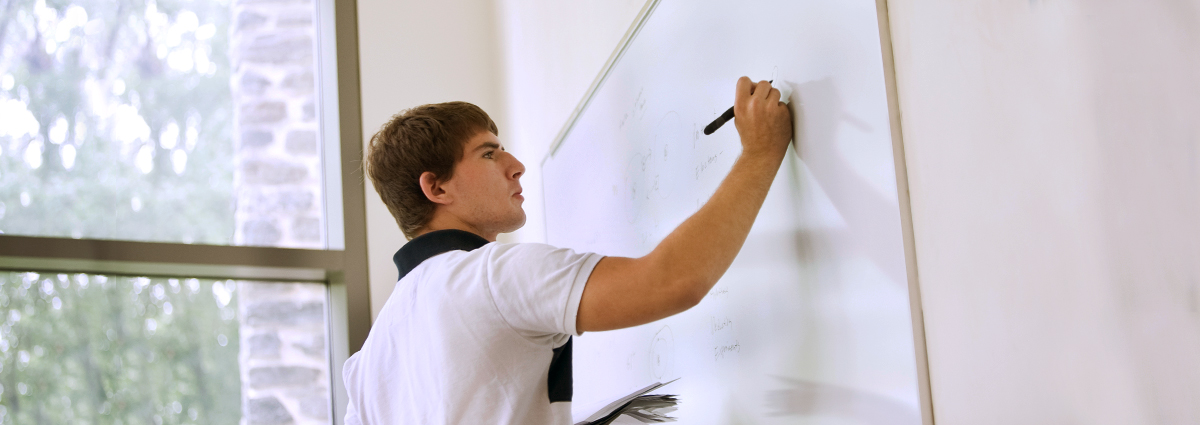 A Cabrini student at a whiteboard
