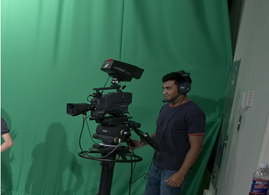 a Cabrini student with a camera in the video studio