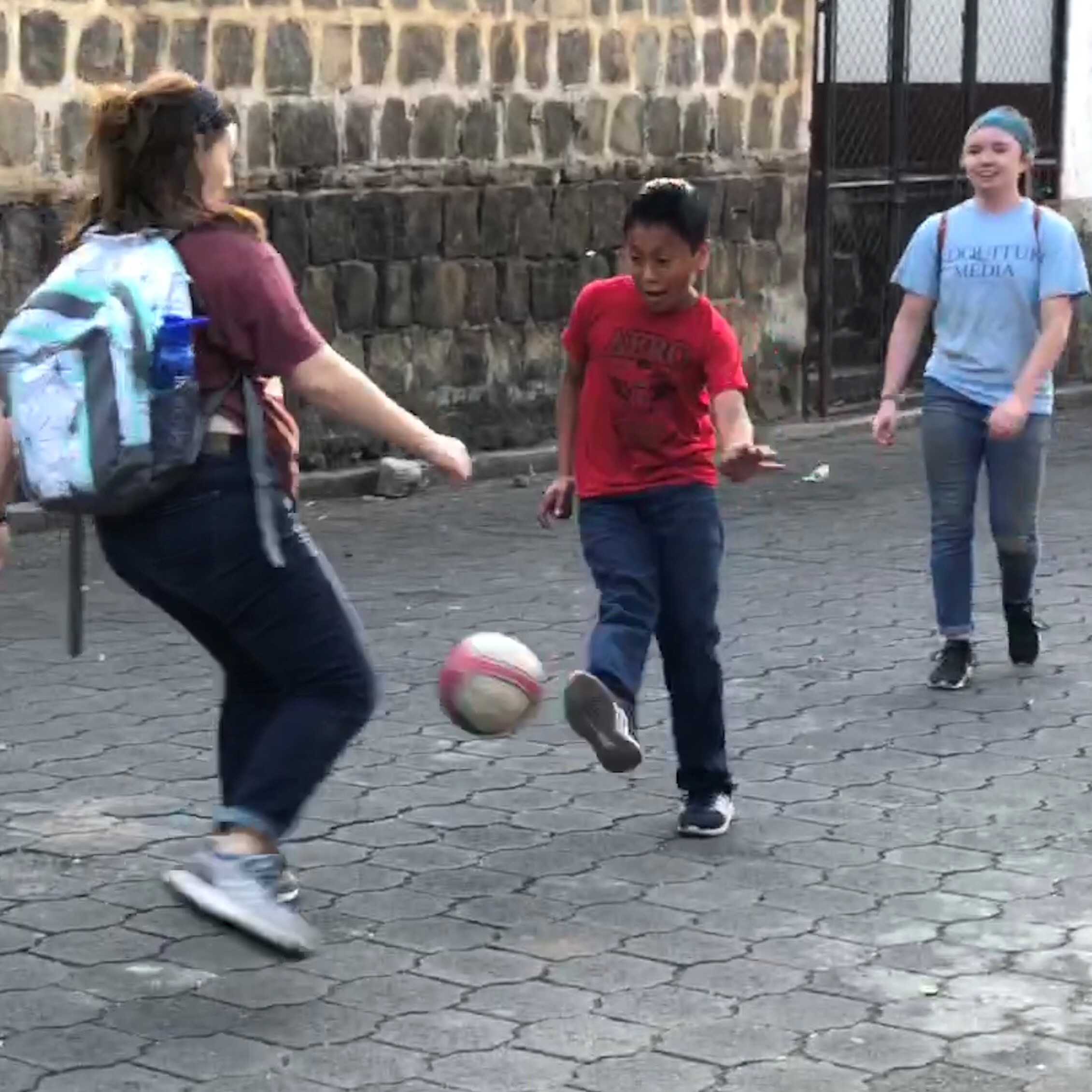 Students playing soccer with a Guatemalan boy