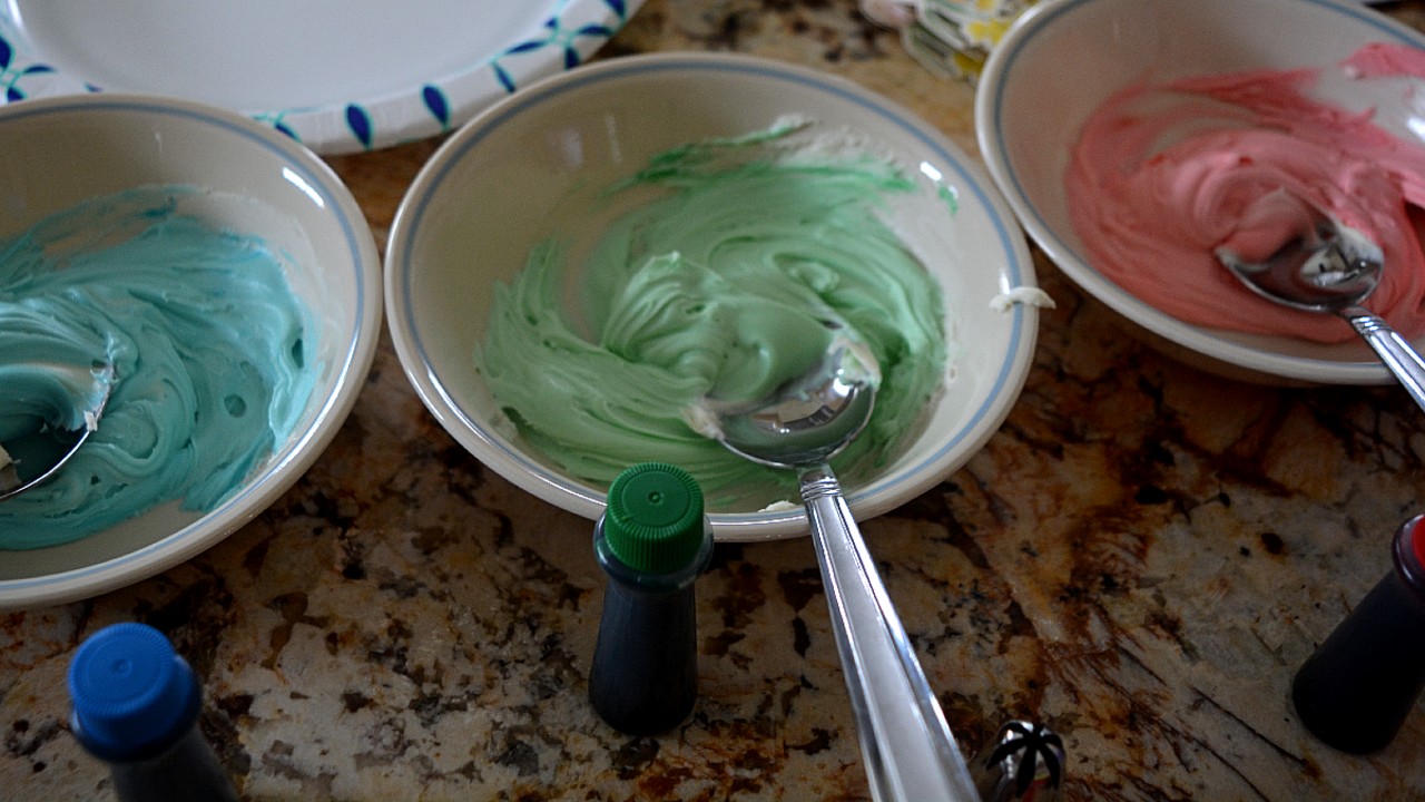 I dyed the white icing using one drop of red, blue, and green food coloring in each bowl and then piped the icing onto the cupcakes!
